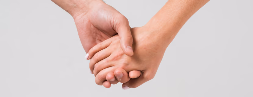 Duas mãos entrelaçadas sobre fundo claro